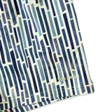 Short de baño azul con estampado de líneas verticales en tonos de azul y blanco. Tiene elástico en la cintura, cordón ajustable, tres bolsillos y mesh interior hipoalergénico.