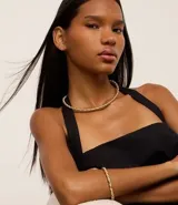 Conjunto de collar gargantilla y pulsera rígida con detalles torcidos, color dorado.