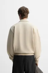 Sudadera negra de algodón con cuello polo y cierre de cremallera.