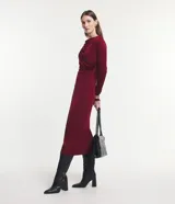 Vestido midi negro de manga larga, confeccionado en malla polyvelour, con cuello drapeado (degagê) y talle ajustado.