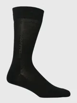 Calcetín de vestir negro, de caña media-alta, con tejido fino y elástico en el borde superior. Presenta el logo de Hush Puppies en vertical en la caña.