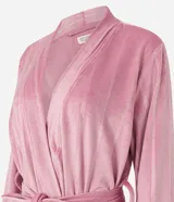 Bata de baño corta color rosado, confeccionada en plush texturizado con rayas verticales. Tiene escote en V cruzado, mangas largas y cinturón para atar.