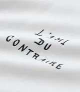 Remera boxy de algodón color crudo, con cuello redondo y mangas cortas. Estampa frontal con la frase "l'ami du contraire" y estampa trasera de figuras estilo art noveau.