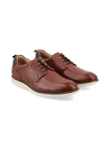 Zapato de vestir de cuero marrón, estilo derby o casual de vestir, con cordones y suela blanca gruesa de goma.