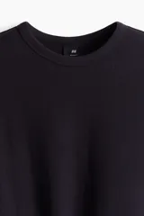 Remera negra de algodón con textura waffle, cuello redondo ribeteado y corte estándar.