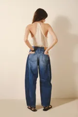 Pantalón jean de tiro alto, corte amplio y pierna ancha con parches en diferentes tonos de azul.