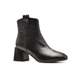 Bota de cuero negra con caña baja, punta fina y taco geométrico.