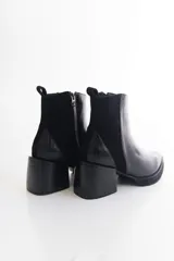 Botas negras de cuero con pulsera de tachas removible y taco de 6 cm.