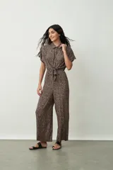 Mono largo negro de corte palazzo con camisa de mangas cortas con botones y lazo en la cintura.