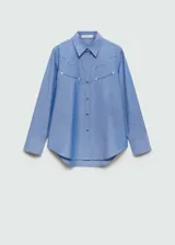 Camisa celeste de manga larga con puños abotonados, diseño recto, cierre delantero de botones a presión, cuello camisero, costuras decorativas, tachuelas decorativas y bordado decorativo.