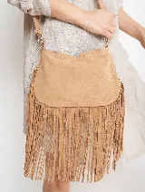 Bandolera de gamuza color beige con flecos largos en la parte inferior. Tiene correa larga regulable y herrajes plateados.