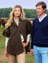 Capa de paño color marrón oscuro, con cuello alto y cierre frontal de tres botones. Confeccionada en lana.