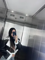 Campera corta negra de cuero sintético con interior y cuello de piel sintética blanca.