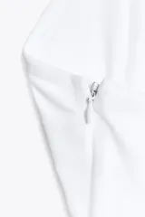 Top blanco de cuello halter y escote pico. Tejido combinado a tono. Bajo acabado tipo globo.