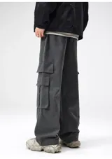 Pantalón cargo negro de corte ancho, confeccionado en gabardina de algodón. Presenta cintura elástica y regulable con cordón blanco, y múltiples bolsillos cargo laterales con costuras destacadas.