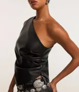 Blusa negra de hombro único confeccionada en poliuretano, con bretel ancho, sin mangas, modelo alargado y franzidos laterales.