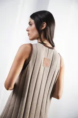 Vestido midi tejido en punto canalé negro con detalles en lurex plateado. Presenta calado artesanal en el ruedo, abertura lateral y etiqueta de cuero en la parte trasera del cuello.