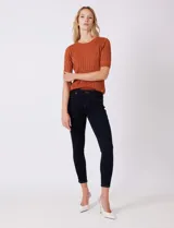 Jean ajustado (skinny) de mezclilla color azul oscuro, corte tobillero, con tiro medio y costuras en contraste.