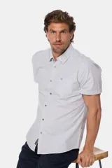Camisa celeste a rayas verticales, de manga corta, con cuello clásico, cierre frontal con botones y bolsillo en el pecho con logo bordado.