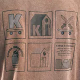 Remera beige con efecto gastado y estampa frontal con el logo de la marca Kaboa Industries.