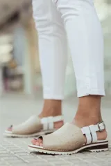 Sandalias de cuero con puntera descubierta, color negro con textura tipo cocodrilo en la parte delantera y tiras de cuero marrón con hebilla dorada en el tobillo.