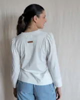 Remera negra de mangas largas con cuello en V y detalles de pespuntes blancos.