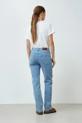 Jean de denim celeste, de corte recto, tiro medio y largo hasta el tobillo.