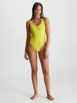 Traje de baño enterizo Calvin Klein color amarillo, con textura de canalé y tirantes anchos negros con el logo de la marca.