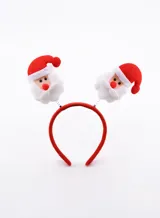 Vincha navideña roja con apliques de Papa Noel a los costados.