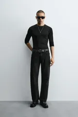 Pantalón de jean celeste de corte flare, con tiro medio, cinco bolsillos, cierre frontal con cremallera y botón, y bajo con acabado irregular.