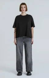 Pantalón de denim 100% algodón, color negro con lavado ácido/desgastado. Diseño de cinco bolsillos y calce wide leg.