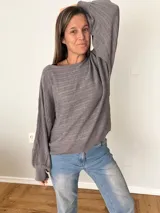Sweater de tejido calado color gris, con cuello redondo y mangas globo.