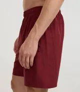 Bermuda deportiva color beige, de tejido plano de poliéster, con cintura elástica y cordón de ajuste. Posee bolsillos laterales con cierre y recortes laterales con perforaciones.