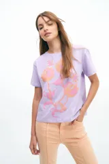 Remera lila de algodón con estampado de flores en tonos naranja y rosa.