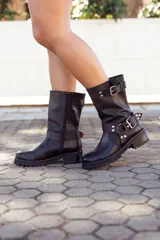 Bota de cuero negra, de caña media, con hebillas y suela track.