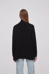Saco negro de viscosa con textura acanalada, corte holgado y mangas largas.