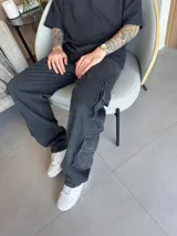 Pantalón cargo negro de corte baggy con cuatro bolsillos grandes con solapa.