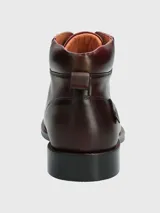 Bota de cuero color marrón con cordones, caña media y suela de goma.