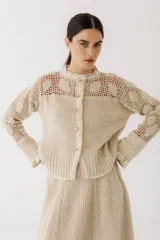 Cárdigan color beige tejido en lambswool con detalles de crochet hechos a mano, de corte ajustado y largo hasta la cintura.