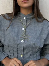 Collar de bronce con cadena de eslabones ovalados y dije grande en forma de sol con rayos.