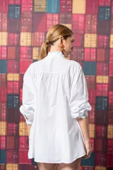 Camisa blanca de algodón con corte amplio, tablitas en la parte delantera y volados en el cuello.