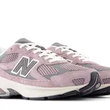 Championes New Balance modelo U2010WCC, color rosado (malva) con detalles en gris y entresuela crema. Presentan una combinación de malla transpirable y gamuza, con el logo 'N' en el lateral.