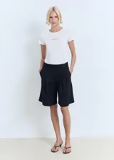 Remera blanca de algodón con cuello redondo y logo 'Mango' estampado en color dorado en el centro del pecho.