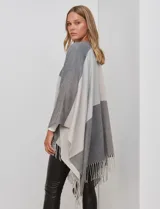 Ruana tejida con diseño colorblock en tonos borgoña, rosa viejo y beige. Presenta flecos en los bordes.