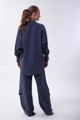 Pantalón cargo azul de tiro alto y corte ancho, con bolsillos laterales con solapa y cintura elástica.