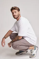 Pantalón de vestir color beige, de corte recto, con bolsillos laterales y traseros. Se ajusta a la cintura con cinturón de cuero marrón.