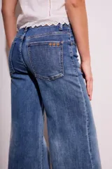 Pantalón de jean de tiro medio, color celeste, corte flared y wide leg.
