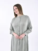 Vestido camisero midi a rayas verticales grises y blancas, con cuello mao y mangas largas abullonadas.