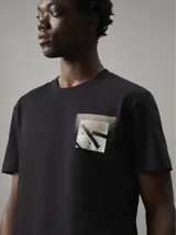 Remera negra de algodón regenerado con cuello redondo y manga corta. Estampado frontal con el monograma de Calvin Klein Jeans enmarcado en un recuadro gris.