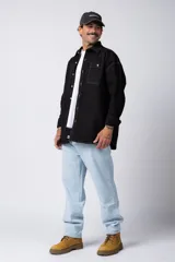 Camisa verde militar de manga larga, corte oversize, con cuello clásico, cierre frontal con botones y bolsillo en el pecho. Confeccionada en algodón suave y con costuras a la vista.